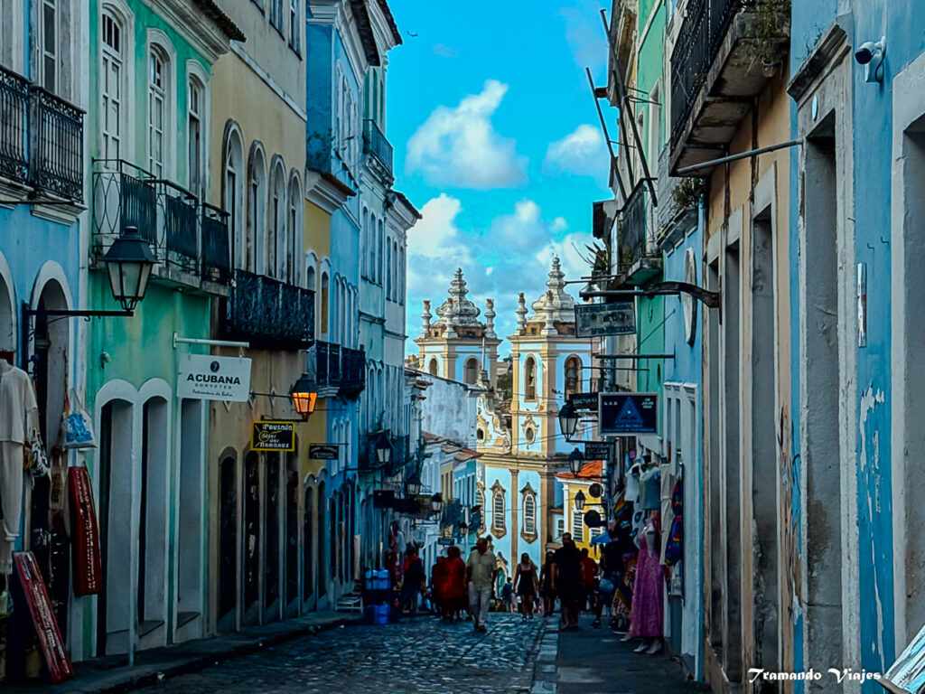 Calle adoquinada del Pelourinho con casas de colores y la Igreja Nossa Senhora do Rosário dos Pretos al fondo