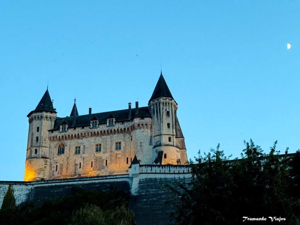 Castillo de Saumur iluminado al anochecer sobre la ciudad